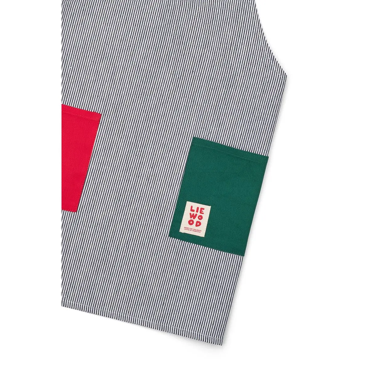 Nahaufnahme der gestreiften Arda-Schürze mit roter und grüner Tasche und kleinem Liewood-Etikett.
