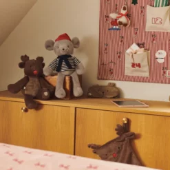 Weihnachtlich dekoriertes Kinderzimmer mit rosafarbenem Adventskalender, Kuscheltieren und Zeichenbrett.