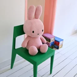 Miffy Corduroy Pink 70 cm – Kuschelhase auf einem grünen Stuhl