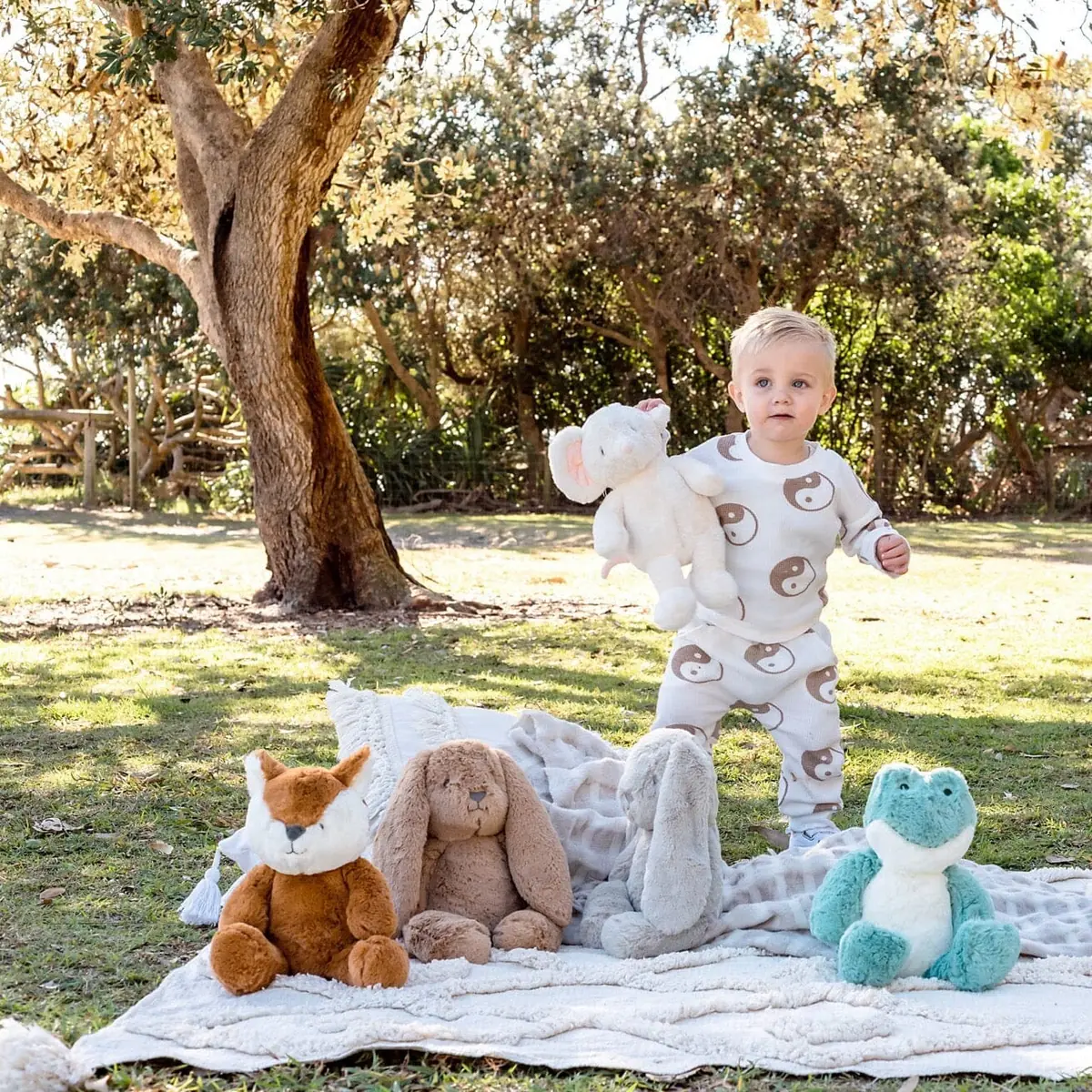 Kind mit Kuschelfuchs Frankie und weiteren Kuscheltieren im Garten – O.B. Designs