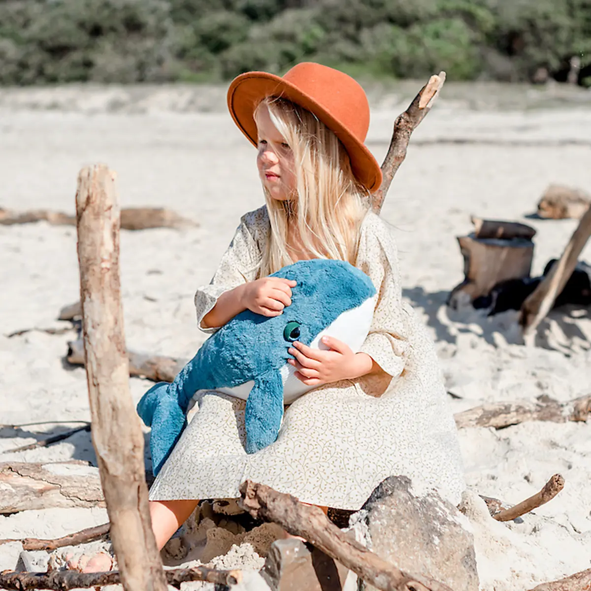 Kind mit blauem Kuschelwal Hurley am Strand – O.B. Designs